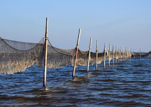 Perspective view of fishing net mounted to wooden poles