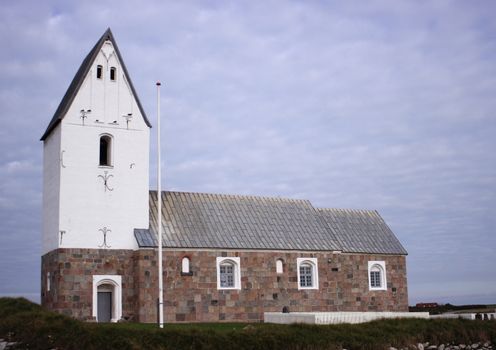 Simple traditional west coast stone church with graveyard at the Northern Sea