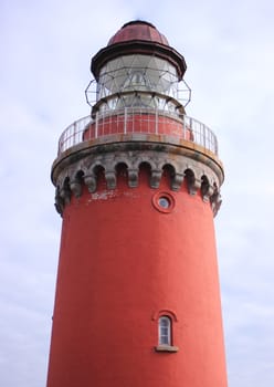 Old red lighthouse at the coast of the Northern Sea