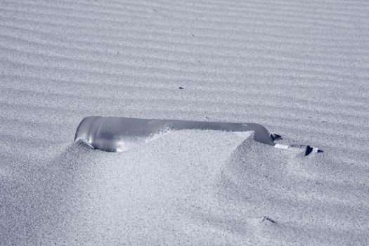 Sand waves with half hidden bottle