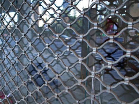 Shop window protected by iron bars security shutter against theft and vandalism