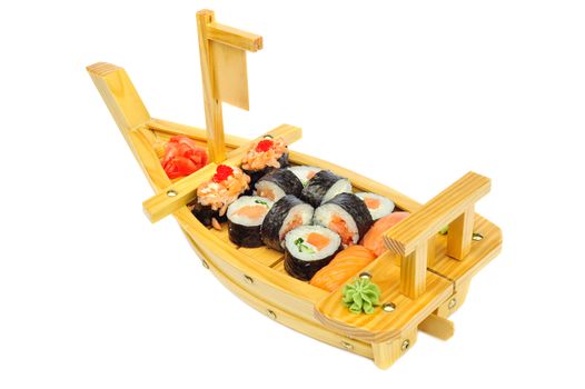 Sushi set assorrted rolls ion ship shaped plate solated on white