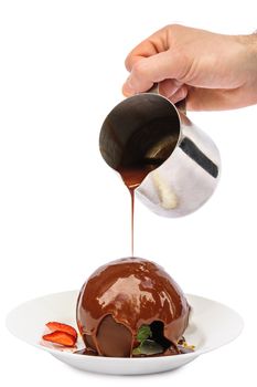 Chocolate dessert sphere with icecream and caramel inside, pouring liquid chocolate on it