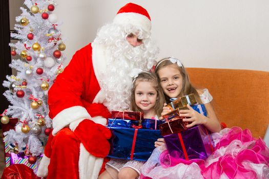 Santa Claus gave presents to the children and hugged