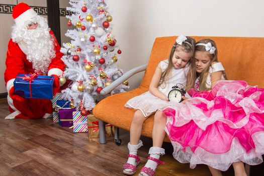 The sisters fell asleep while waiting for Santa Claus, who quietly put presents under the Christmas tree