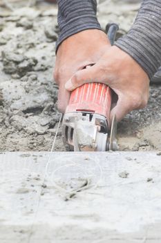 Mason cutting tiles to repair by metal grinding