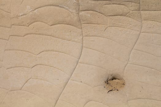 Light brown color of the sand stone, creating a texture with lines. Hole with sand inside.