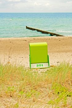 lonely beach chair at beach with ocean baltic sea and wave breaker in the background