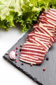 slices of sausage with lettuce and spices