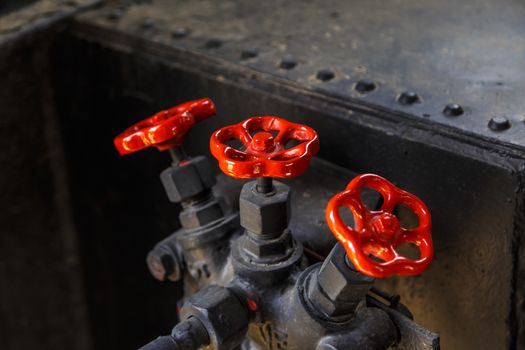 Close up detailed view of industrial iron valves and cables used in mechines.