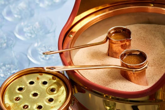 Preparation of Turkish coffee in the cezve in the sand at the cafe bar