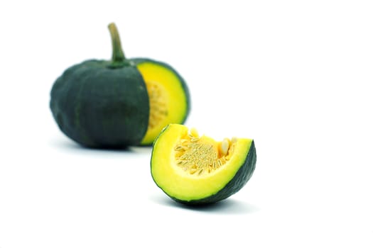 A yellow piece of pumpkin and green pumpkin on white background. A yellow sliced pumpkin and green pumkin on white background.