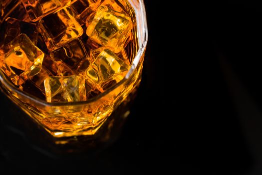 Whisky and Ice on a black glass table