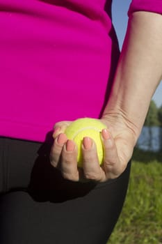 Athlete woman holding a yellow tennis ball