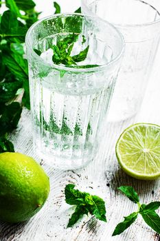 refreshing summer drink cocktail with lime and mint on a light background