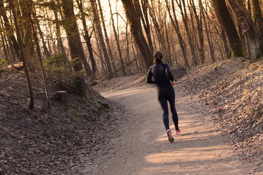 Lady running in the forest.  Running woman. Female runner jogging during outdoor workout in a Nature. Fitness model outdoors. Weight Loss. Healthy lifestyle. 