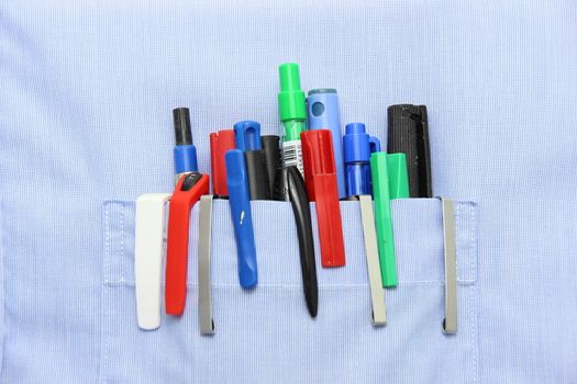 Blue shirt pocket with many different ballpoint pen