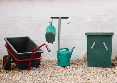 Green and black gardening tools at graveyard