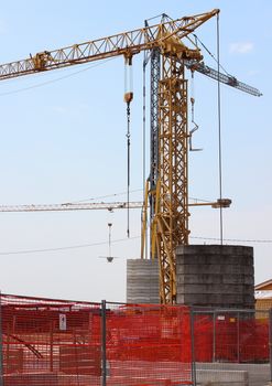 Construction crane with heavy contrablocks and blue sky