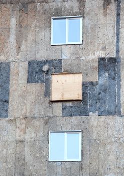 Apartment building under renewal with three windows