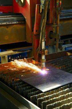 Industrial cnc plasma cutting of metal plate. Closeup