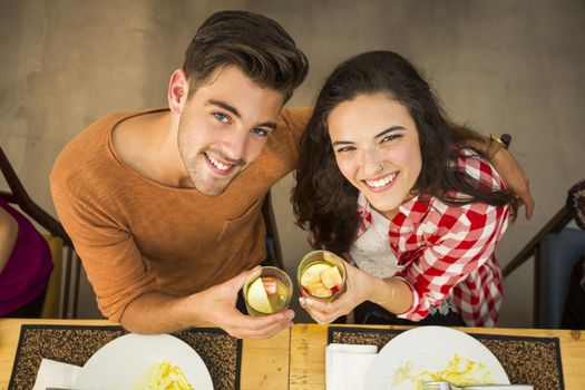 Young couple toasting and looking happy at a restaurant