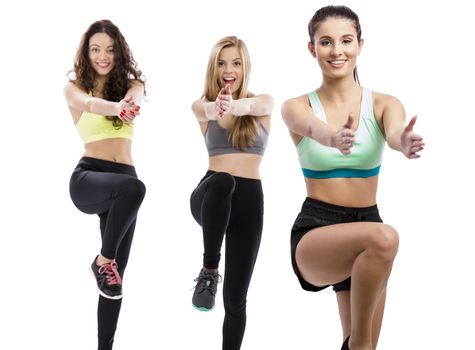 Portrait of three beautiful athletic girls making group exercises