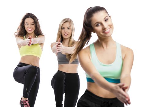 Portrait of three beautiful athletic girls making group exercises