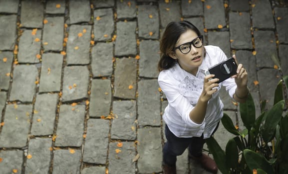 Young women take photos from a camera in a mobile phone.