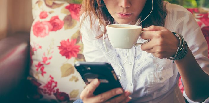 Women drinking coffee and playing mobile phone in a relaxed mood photos style vintage.