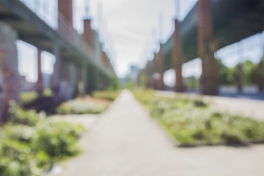 Unfocused blurred view on bridge and summer alley