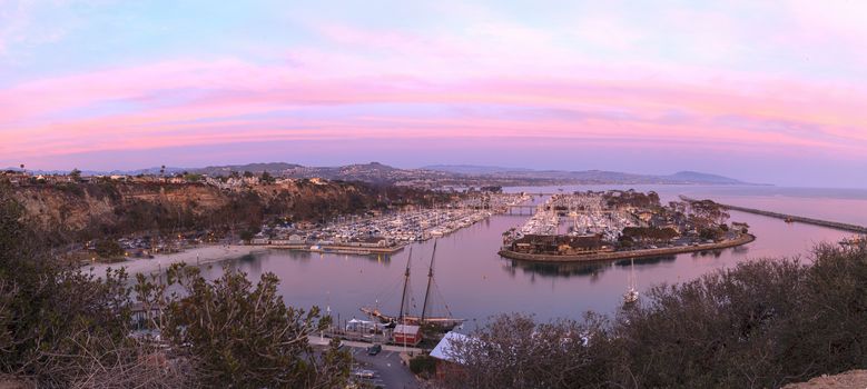 Panoramic Dana Point harbor view of the sunset and a private beach below