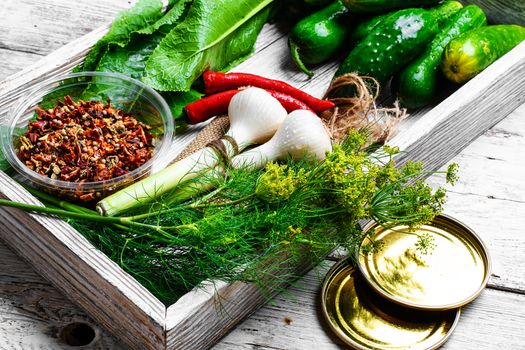 Wooden box with cucumbers and vegetables prepared for seaming