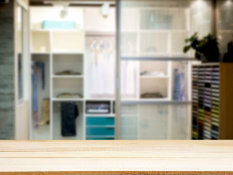 Wooden board empty table in front of blurred background. Perspective light wood over blur in closet room for background uses. Mock up for display of product.