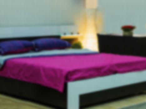 Abstract blur Interior of modern comfortable hotel bedroom. Blurred bedroom with purple and violet bed