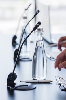 Microphones on table in conference room and business man hands 