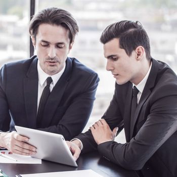 Business people discussing the charts and graphs showing the results of their successful teamwork