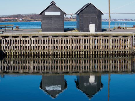 Blue water ripples background -  Two small wooden sheds reflected in the water     