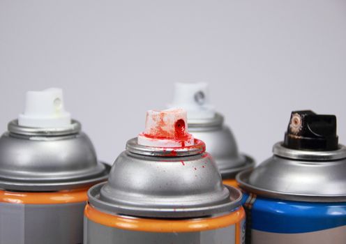 Top of four isolated spray cans with different colors