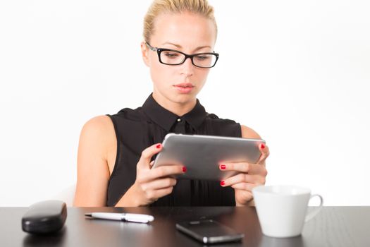 Business woman in office working on her tablet PC. 
