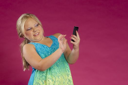 A young child posing in a studio environment with an electronic device.