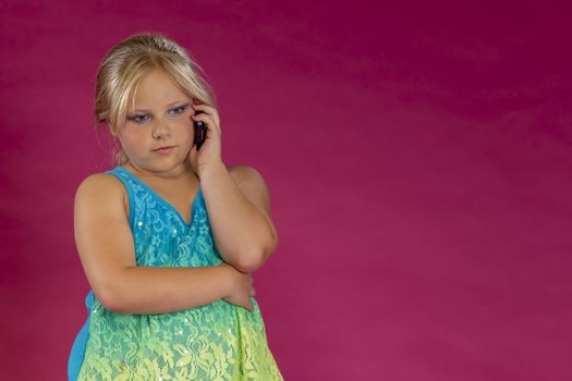 A young child posing in a studio environment with an electronic device.