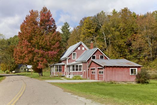 Weathered red wooden house and Autumn foliage, Vermont, USA