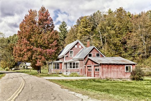 Weathered red wooden house and Autumn foliage, Vermont, USA