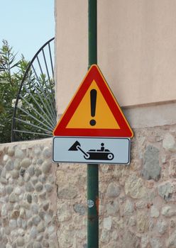 Road sign with bulldozer on metal post