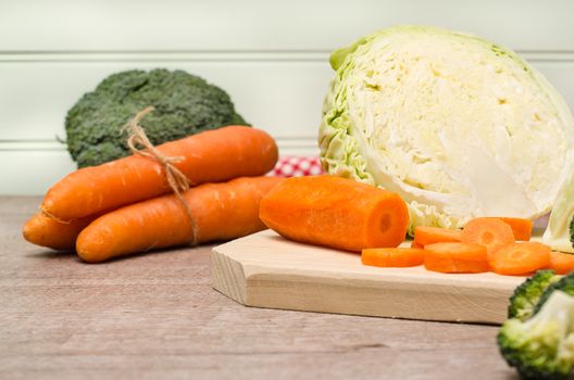 Fresh vegetables from the garden, carrots, cabbage, broccoli, onion and garlic on a wooden table. Vegetables for preparing soup