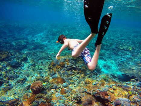 Underwater shoot of a young boy snorkeling and diving in a tropical sea in Nusa penida, Indonesia, Bali
