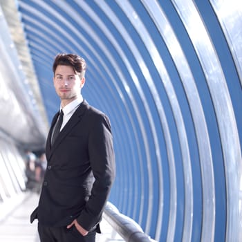 Young Businessman standing in corridor of modern office building