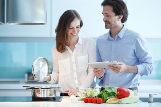 Portrait of a couple having a glass of red wine while cooking dinner