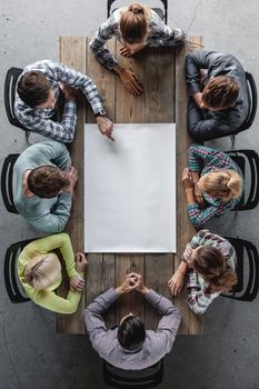 Hipster business teamwork brainstorming planning meeting concept, people sitting around the table with white paper